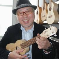 Eisuke Miyagi plays a ukulele in Chitose, Hokkaido, made with local wood. | KYODO