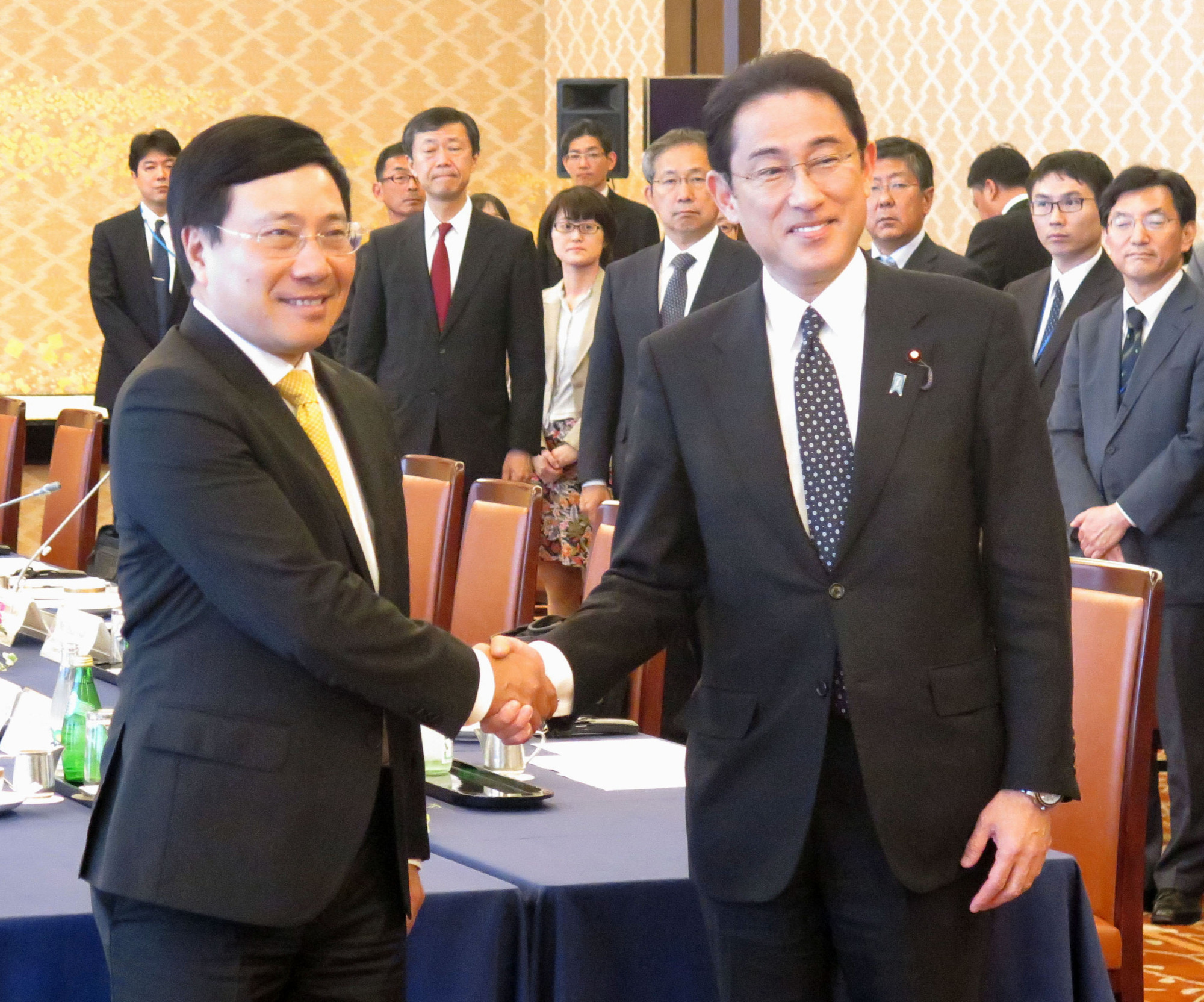 Vietnamese Deputy Prime Minister Pham Binh Minh (left) is greeted by Foreign Minister Fumio Kishida ahead of their talks in Tokyo on Monday. | KYODO