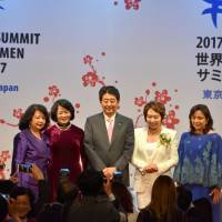 Prime Minister Shinzo Abe poses with the organizers of the 2017 Global Summit of Women on Thursday. | SATOKO KAWASAKI