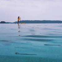 Another day at the office: A lifeguard navigates the waters off Zamami Island. | ANDREW CURRY