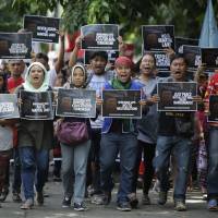 Filipino activists shout slogans as they march toward Camp Aguinaldo military headquarters in Manila during a Monday rally to oppose the declaration of martial law in Mindanao. | AP
