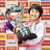 Mai Murakami holds the trophy after winning the all-around title at the NHK Cup Saturday. | KYODO