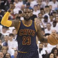 The Cavs’ LeBron James brings the ball up the court during Cleveland’s win over Toronto on Sunday. LeBron, Cavaliers complete sweep of Raptors