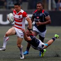 The Brave Blossoms\' Naoki Ozawa is tackled by Hong Kong\'s Phil Whitfield during the Asia Rugby Championship on Saturday in Hong Kong. Japan defeated Hong Kong 16-0 to defend its title. | REUTERS