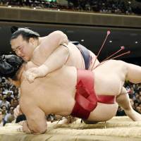 Kisenosato (top) takes down Daieisho at the Summer Grand Sumo Tournament on Friday. | KYODO