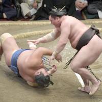 Hakuho overpowers Kotoshogiku on Sunday during their Summer Grand Sumo Tournament match at Ryogoku Kokugikan. | KYODO