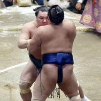 Harumafuji (rear) grapples with Tochiozan at the Summer Grand Sumo Tournament on Tuesday. Harumafuji won and improved to 10-0 at the 15-day meet. | KYODO