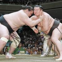 Yokozuna Hakuho (right) battles Terunofuji during their match on the 14th day of the Summer Grand Sumo Tournament on Saturday. Hakuho won to clinch the title with a day to spare. | KYODO