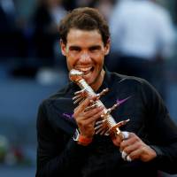 Rafael Nadal bites the trophy after winning the Madrid Open on Sunday. Nadal bests Thiem for Madrid Open crown