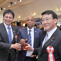 Toast masters: Royce Kuzwayo (center), charge d\'affaires of the Republic of South Africa raises his glass with Shunsuke Takei (left), parliamentary vice-minister for Foreign Affairs, and Asahiko Mihara (right), acting chairperson of the Japan-African Union Parliamentary Friendship Association, during a reception celebrating South Africa\'s Freedom Day at Hotel Okura Tokyo on April 26. | YOSHIAKI MIURA