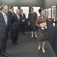 Princess Takamado (right), honorary president of the \"Japan through Diplomats\' Eyes\" exhibition, shows one of her artworks to (from right) Luxembourg Ambassador and Executive Committee Chairman Beatrice Kirsch; Upper House member and head of the jury Hirofumi Nakasone; Venezuela Ambassador and Executive Committee member Seiko Ishikawa; and Canon Marketing Japan Inc. Chairman Haruo Murase at Canon Open Gallery in Tokyo on May 11. | YOSHIAKI MIURA