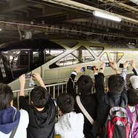 Rail fans take photos of JR East\'s new luxury Shiki-Shima sleeper train during its debut at JR Ueno Station in Tokyo on Monday. The train can accommodate just 34 passengers and is equipped with a lounge and a cypress wood bathtub. For its inaugural four-day journey, the Shiki-Shima will travel to Nikko in Tochigi Prefecture, Aomori Prefecture and Hokkaido. | KYODO