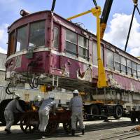 A Keikyu Corp. train built in 1929 and had been kept at a park in Kawaguchi, Saitama Prefecture, since 1979 after retiring is brought to Yokohama Wednesday for restoration. It is expected to be put on display at the firm\'s headquarters when it moves from Tokyo\'s Minato Ward to Yokohama in 2019. | KYODO