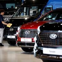 A staffer polishes Hyundai vehicles at a showroom in Goyang, South Korea, last month. | REUTERS