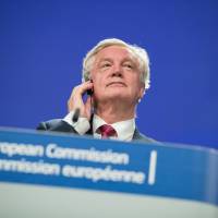 David Davis, U.K. exiting the European Union secretary, listens during a news conference following the start of Brexit negotiations in Brussels on Monday. The U.K. and the European Union moved to reassure millions of their citizens that they won\'t be forced to leave their homes or find new jobs after Brexit, as negotiations on Britain\'s withdrawal finally got underway. | BLOOMBERG