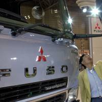 A man looks at a Mitsuibishi Fuso truck in a showroom. Mitsubishi Fuso Truck &amp; Bus Corp. saw its sales in Indonesia jump by nearly a quarter in the first five months of 2017. | C. PERTWEE / BLOOMBERG NEWS