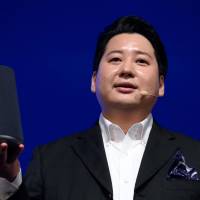 Jun Masuda, chief strategy and marketing officer of Line Corp., holds the company\'s Wave smart speaker during the companys annual strategy briefing in Tokyo on Thursday. | BLOOMBERG