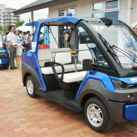 Self-driving vehicles are readied for a road test Monday in Chatan, Okinawa Prefecture. | KYODO