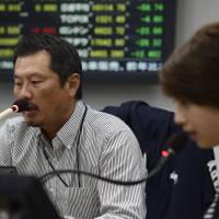 Currency traders handle deals at the offices of Ueda Harlow Ltd. in Tokyo. Japan’s drive to promote yen use abroad is being tested amid a gradual economic recovery. Japan's drive for yen as international currency faces stiff competition from China