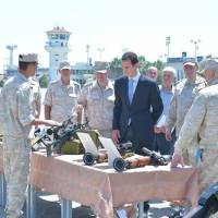 Syrian President Bashar Assad visits a Russian air base at Hmeymim, in western Syria in this handout picture posted on SANA on Tuesday. | SANA / HANDOUT / VIA REUTERS