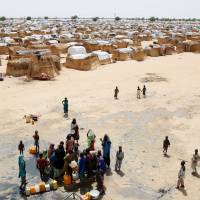 Children fetch water from a borehole point at an internally displaced persons (IDP) camp on the outskirts of Maiduguri, northeast Nigeria, Tuesday. Suspected Boko Haram fighters attacked Maiduguri Wednesday. | REUTERS