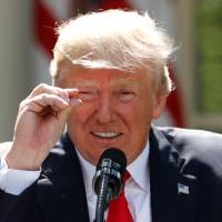 U.S. President Donald Trump refers to the amount of temperature change as he announces his decision that the United States will withdraw from the landmark Paris Climate Agreement, at the White House in Washington on Thursday. U.S. states, cities and firms unite behind Paris accord