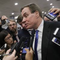 Senate Intelligence Committee Vice Chairman Sen. Mark Warner,  whose panel is investigating Russian interference in the 2016 election, speaks with reporters after final votes for the week, at the Capitol in Washington June 22. | AP