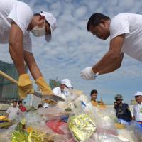 Cambodian officials prepare drugs for a destruction ceremony to mark the U.N.\'s International Day against Drug Abuse and Illicit Trafficking in Phnom Penh on Monday. | AFP-JIJI