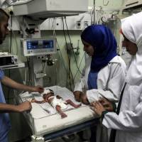 Palestinian nurses tend to a newborn at the neonatal intensive care unit at the UAE hospital in Rafah in the southern Gaza Strip on Tuesday. Hamas accused the Palestinian Authority and Israel of refusing to grant documents to Gazans in need of permission to seek medical treatment outside the blockaded coastal enclave. Palestinian Authority, Israel denying travel documents for sick Gazans: Hamas