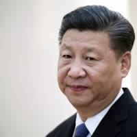 China\'s President Xi Jinping waits to greet foreign ministers of BRICS countries at the Great Hall of the People in Beijing on June 19. | NICOLAS ASFOURI / POOL VIA AP