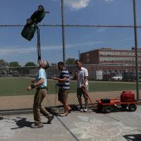 Ashrita Furman tries for a new record in New York on Thursday. New York man balances lawn mower on chin to set fresh world record