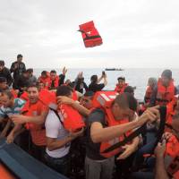 Migrants on a wooden boat are rescued by Save the Children NGO crew from the ship Vos Hestia in the Mediterranean sea off Libya Sunday. | REUTERS