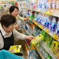 In Kira, Aichi Prefecture, seniors place products on store shelves at an outlet of the Sugi Pharmacy drugstore chain. | CHUNICHI SHIMBUN
