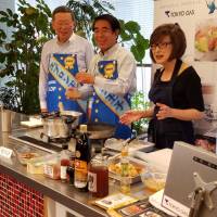 LDP veterans Hakubun Shimomura (center) and Jiro Kawasaki (left) get a taste of cooking duties in a Tokyo studio on Wednesday as they are taught how to make karaage, or deep-fried chicken. | TOMOHIRO OSAKI