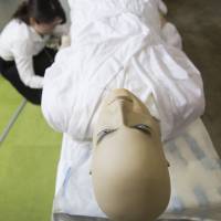 A sheet to prevent odor and bacteria is displayed under a mannequin at the Funeral Business Fair 2017 in Yokohama on June 26. Over 120 businesses exhibited its products and services for funeral, burial and memorial services during the two-day fair. A decade after pivotal legal battle, embalming on rise as Japanese seek dignity for the dead