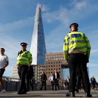 Commuters walk past a police officer on London Bridge on Monday after dozens of pedestrians were attacked over the weekend. Study abroad and travel agencies on edge in wake of London Bridge attack