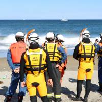 Rescue workers in Natori, Miyagi Prefecture, search for a 16-year-old high school boy who went missing Sunday after being swept away from his boat by waves. | KYODO