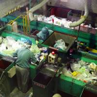 Workers sort plastic waste at the Minato Resource Recycle Center in Tokyo. | TIM HORNYAK