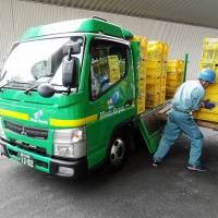Crates of bottles are unloaded at the Minato Resource Recycle Center in Tokyo. | TIM HORNYAK