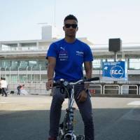 At the wheel: Super GT driver Jann Mardenborough rides out of the pits to the Team Impul truck in the paddock at Autopolis in Oita Prefecture. | OSCAR BOYD