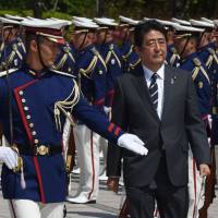 Prime Minister Shinzo Abe, shown reviewing an honor guard at a Tuesday ceremony to mark the return of SDF peacekeepers, is on an ideological mission to reshape the Japanese state. Shinzo Abe and the arrogance of power