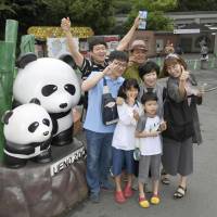 Konnichiwa, akachan: Visitors to the Ueno Zoological Gardens celebrate a day after the birth of a giant panda cub. | KYODO