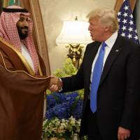 Saudi Defense Minister and then-Deputy Crown Prince Mohammed bin Salman shakes hands with U.S. President Donald Trump during a bilateral meeting in Riyadh on May 20.  Salman, who was named crown prince on June 21, has been responsible for a more aggressive Saudi stance in regional affairs. | AP