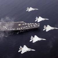 Air Self-Defense Force F-15 fighters fly over the U.S. Navy aircraft carrier Carl Vinson during a Japan-U.S. joint training drill exercise in the Sea of Japan on June 1. Giving Japan a military