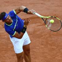 Rafael Nadal serves to Nikoloz Basilashvili during their third-round match at the French Open on Friday. Nadal overwhelms Basilashvili in third round
