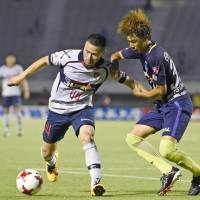 FC Tokyo\'s Takuma Abe (left) holds off Sanfrecce Hiroshima\'s Taishi Matsumoto during their J. League Cup playoff first-leg match on Wednesday. | KYODO
