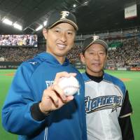 Hokkaido Nippon Ham\'s Toru Murata celebrates the Fighters\' 5-1 win over the Giants alongside manager Hideki Kuriyama at Sapporo Dome on Sunday. | KYODO
