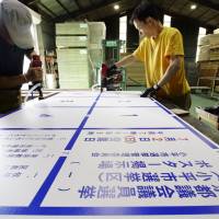 Workers at Shinano Screen Kogei Co. create boards on Tuesday to display posters for candidates for the Tokyo Metropolitan Assembly election in Chikuma, Nagano Prefecture. Campaigns for the election will kick off on June 23 with voting slated for July 2. | KYODO