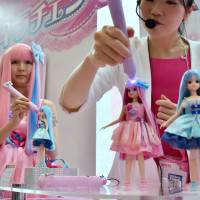 A Tomy Co. employee demonstrates how Kirachen Licca-chan changes its hair color by casting a special light with a pen-shaped tool during the annual International Tokyo Toy Show. The event kicked off Thursday at Tokyo Big Sight in Koto Ward. | SATOKO KAWASAKI