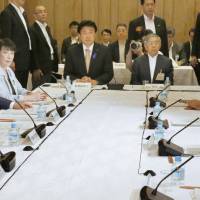 Members of the government\'s economic policy panel gather at the Prime Minister\'s Office on Friday evening to discuss next year\'s budget. | KYODO